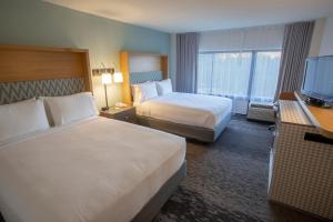 奥兰多Holiday Inn Orlando International Airport, an IHG Hotel的酒店客房设有两张床和一台平面电视。