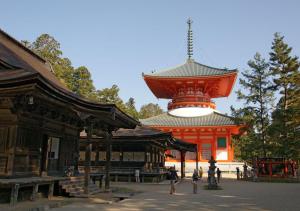 桥本Hostel Inn Hashimoto的一座橙色的建筑,上面有一座红塔