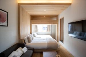 东京Sakura Cross Hotel Shinjuku East的一间卧室配有一张床、一张沙发和一台电视。