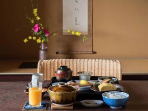 松山道后温泉大和屋别荘的一张桌子,上面放着一盘食物和橙汁