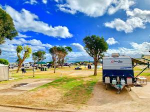 杰拉尔顿日落海滩假日露营地的停在公园里的蓝色和白色拖车
