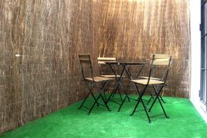 加的斯Plaza de España building的两把椅子和一张桌子,铺有绿色地毯