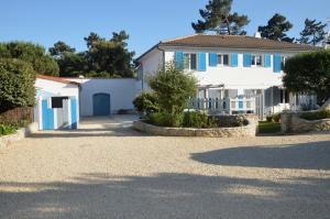 圣特罗让莱班Chambre indépendante dans une villa的白色的房子,有蓝色的窗户和车道