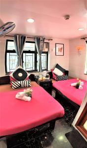 香港Cebu Inn的配有红色靠垫的客房内的两张床