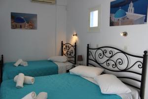 佩里萨Spiridoula Villa - Santorini Seaside Retreats的蓝色和白色的客房内的两张床
