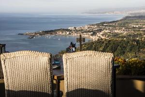 陶尔米纳都卡雷别墅酒店的一张桌子和椅子,享有海景