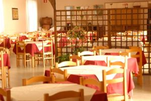 圣温琴佐圣卡塔林纳酒店的一间设有桌椅的红色桌布客房