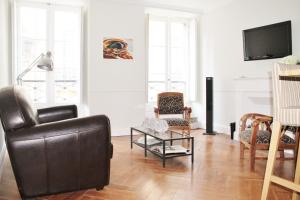 波尔多拉博迪欧提恩公寓的客厅配有黑色真皮沙发和椅子