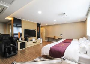晋州市No.1 New Yorker Hotel的配有一张床和一台平面电视的酒店客房