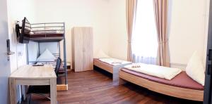 梅明根FMM Hostel的客房设有两张双层床和一张书桌。