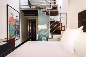 马德里Hotel Urban,a Member of Design Hotels的一间卧室设有一张床和一个楼梯