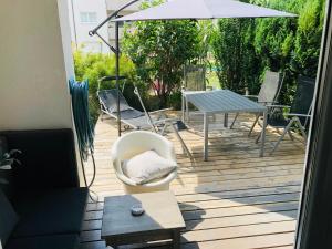 滨湖新锡德尔25h GARDEN Apartment PLUS private Beach的庭院配有桌椅和遮阳伞。