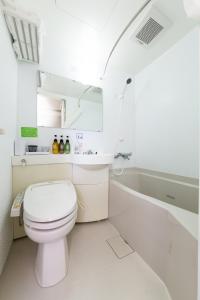 四日市四日市站前三交酒店的白色的浴室设有卫生间和浴缸。