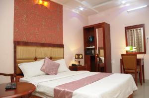 迈索尔国王凯斯特酒店的一间卧室配有一张大床和一张桌子