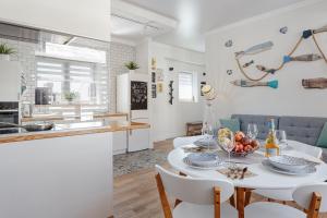 敖德萨Scandi Apart Odessa的厨房以及带白色桌椅的起居室。