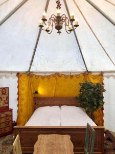 马尔默Grand Circus Hotel的帐篷内的一张床位,配有桌子和吊灯