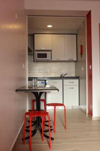 巴勒尔Baleal à Vista的厨房配有桌子和2张红色凳子