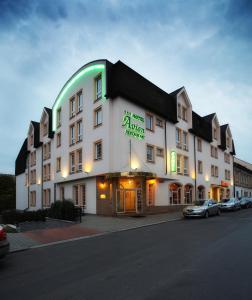 布拉格艾维酒店的一座白色的大建筑,上面有绿色的标志