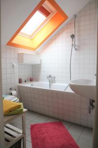 吕本Altes Gärtnerhaus的带浴缸、水槽和天窗的浴室