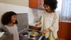 亚的斯亚贝巴Victoria Guesthouse Addis的女人和女孩在厨房准备食物
