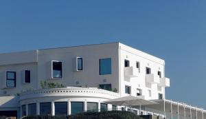 比斯卡罗斯海滩德拉普拉奇乐格兰德酒店的前面有一把伞的白色建筑