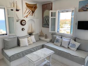 皮索利瓦迪Aiolos Home with private veranda and amazing sea views, Paros的带沙发和2扇窗户的客厅