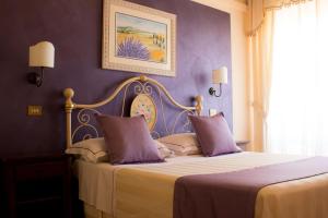 蒙特普齐亚诺Hotel Ristorante Tre Stelle的一间卧室配有一张紫色墙壁的床