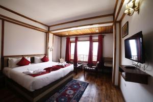 拉瓦格拉Buddha Retreat的一间卧室配有一张大床和电视