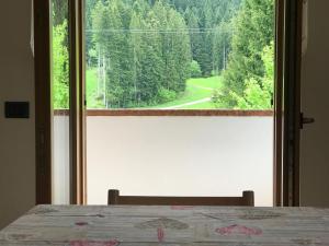 安达洛Appartamenti Rì de Clama的一间卧室设有享有森林美景的窗户