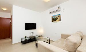 巴特亚姆巴特亚姆旅游4号公寓的客厅配有沙发和墙上的电视