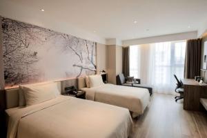 上饶上饶凤凰大道亚朵酒店的酒店客房设有两张床和大窗户。
