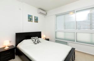 巴特亚姆巴特亚姆旅游4号公寓的一间卧室设有一张床和两个窗户。