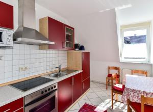 HochbuchFerienwohnungen Meyer的一间带红色橱柜和水槽的厨房