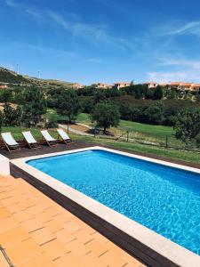 托里什韦德拉什Villa with swimming pool in Golf Resort的一个带椅子的游泳池,享有房子的景色