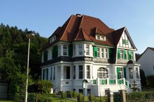 索林根比苏别墅酒店的一间白色的大房子,有棕色的屋顶