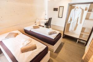 泰塞罗Hotel La Sorgente的配有两张床铺的客房配有一张桌子和一面镜子