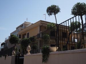 格拉维纳迪卡塔尼亚Viaggio in Sicilia B&B的一座建筑,上面有带盆栽树木的栅栏