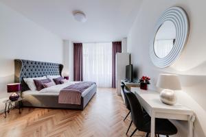 布拉格Gold Art Apartments的一间卧室配有一张床、一张书桌和一面镜子