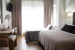 格罗韦Hotel Maruxia *** Superior的酒店客房设有两张床、一张书桌和一个窗户。