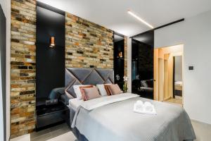 华沙ZLOTA Luxury Apartments的一间卧室设有一张床和砖墙