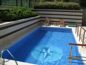 卡瓦尔纳阿莱格拉别墅酒店的一座大型蓝色游泳池旁配有两把椅子