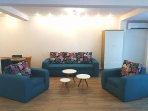 北马马亚-讷沃达里Casa Maria Mamaia Nord的客厅配有2张蓝色的沙发和1张桌子