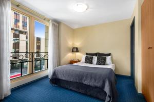 霍巴特萨沃伊探索酒店的一间卧室设有一张床和一个大窗户