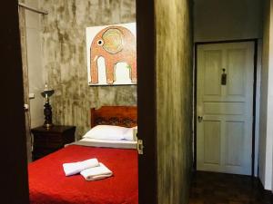 清迈Bee Friend Hostel的一间卧室配有红色的床和毛巾