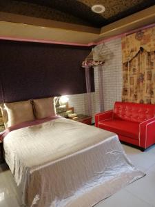 土城区雪瓈花园汽车旅馆的一间卧室配有一张床和一张红色的沙发