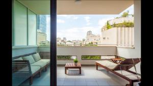 特拉维夫Sunny Luxury Apartments的阳台设有带沙发和椅子的客厅