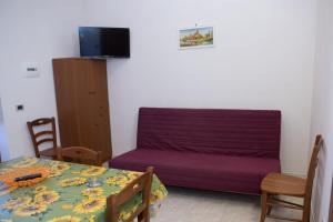帕基诺Casa Vacanze Calafarina的客厅配有紫色沙发和桌子