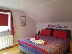 托尔豪特伍德赛德床和早餐旅馆的一间卧室配有一张带红色和蓝色毯子的床