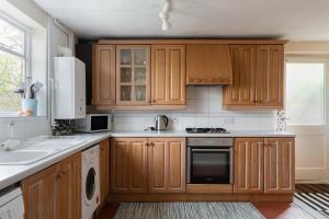 亨利昂泰晤士Henley self catering House的一个带木制橱柜和水槽的厨房