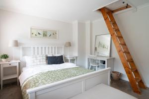 亨利昂泰晤士Henley self catering House的白色的卧室,配有床和梯子